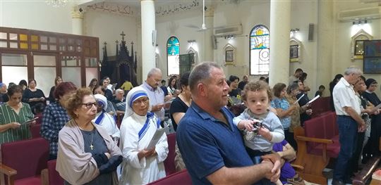 Cristiani in preghiera nella chiesa della Sacra Famiglia di Gaza, durante il conflitto